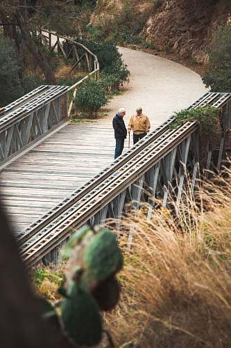 human two men standing on bridge banister