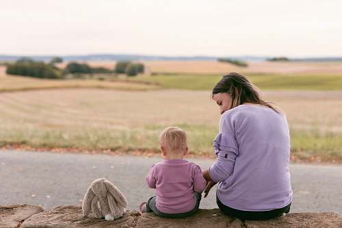 human woman and child sitting next to each other apparel