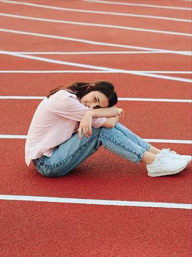 human woman sitting on track field running track