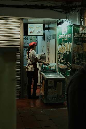 human woman wearing white crew-neck shirt and black apron holding white plastic crate wilayah persekutuan