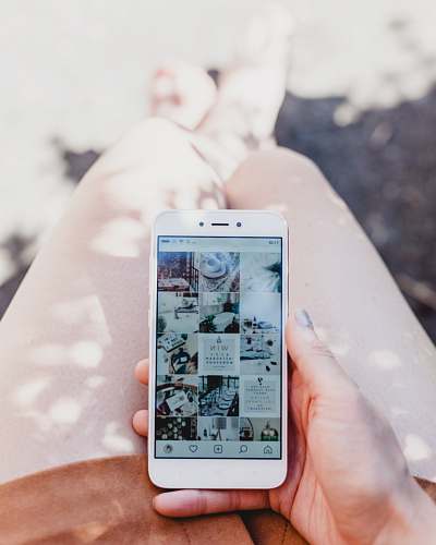 social person holding white smartphone showing Instagram feed gloucester road
