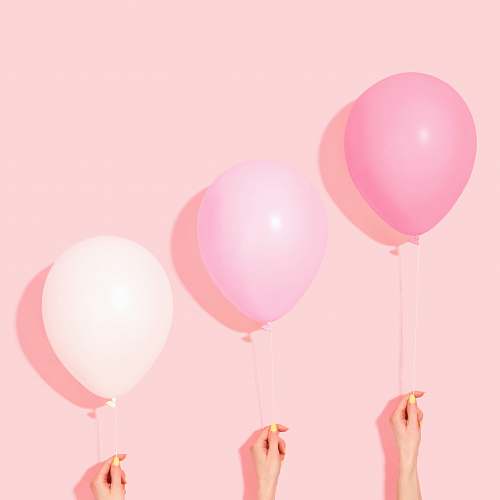 balloon person holding pink and white balloon ball