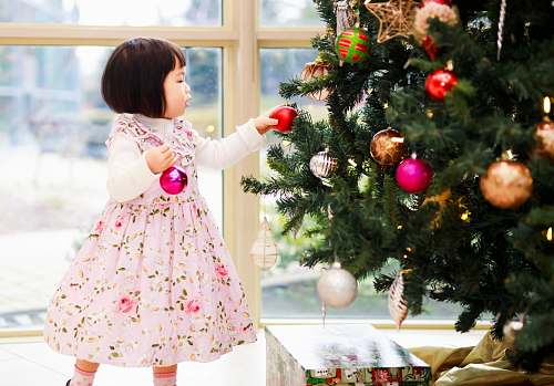 tree girl holding baubles near the Christmas christmas tree