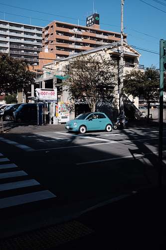 asphalt blue car parked beside building tarmac