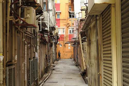 city boy standing in alley building