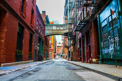 city empty road between brown buildings during daytime town