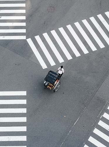 asphalt man pulling carriage crossing pedestrian tarmac