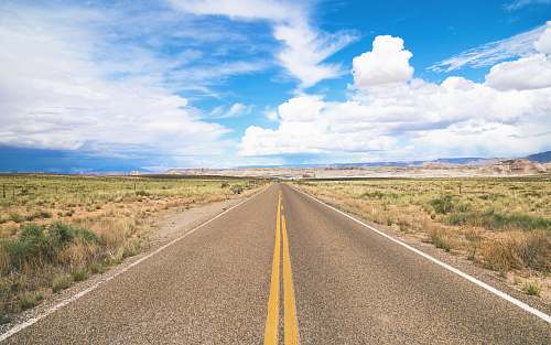 landscape narrow road under cloudy skies at daytime freeway