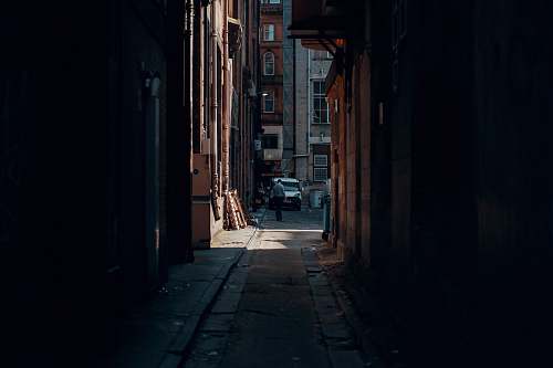 city person walking beside building near vehicle urban