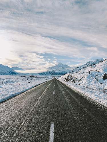mountain road near mountain covered with snow snow