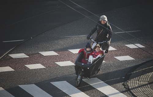 asphalt woman and two children riding on trike tarmac