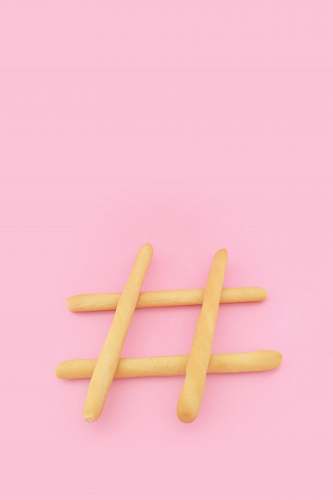 food four brown wooden sticks on pink surface pink