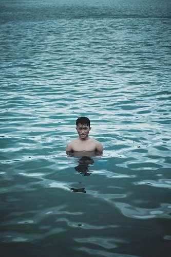 human man bathing on calm water person