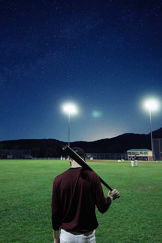 person man holding baseball bat on green field baseball