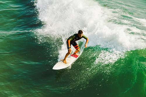 sea man on surfboard surfing against waves surfing
