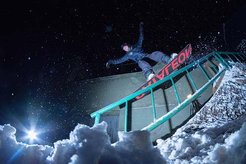 sports man riding on snowboard at nighttime nature