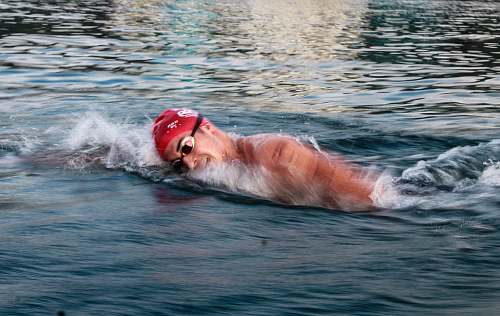 person man swimming on body of water during daytime human