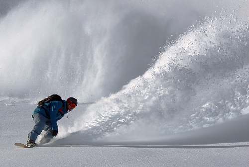 snowboarding person gliding in snow during day time snow
