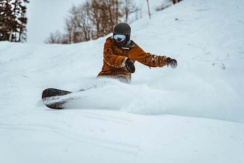 snowboarding photography of person playing snowboarding during daytime outdoors