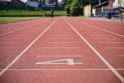 sports rubberized track field at daytime person