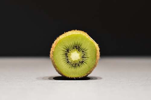 sports sliced kiwi on white surface ball