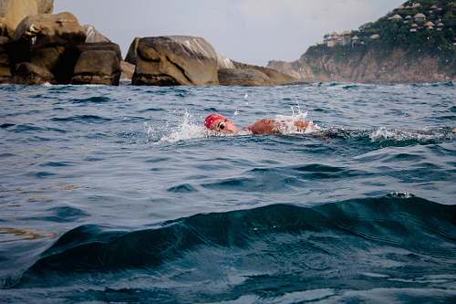 person man swimming in sea during daytime water