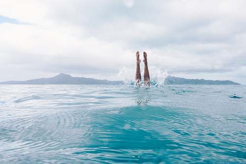 water person diving on body of water during daytime sport