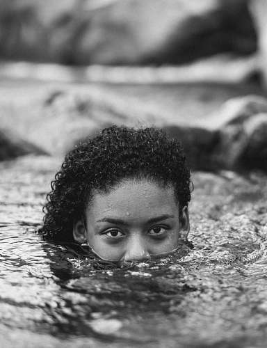 person woman with half of her face under water black-and-white