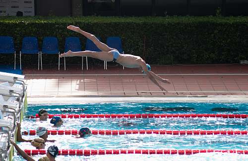 sports man dive on swimming pool during daytime diving