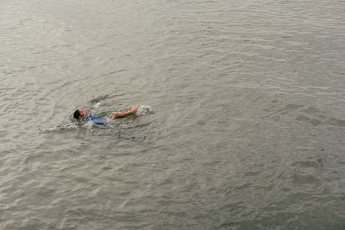 person person swimming on calm body of water human