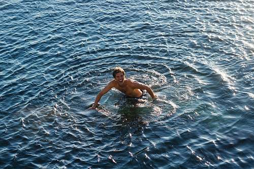 swimming topless man swimming in body of water human