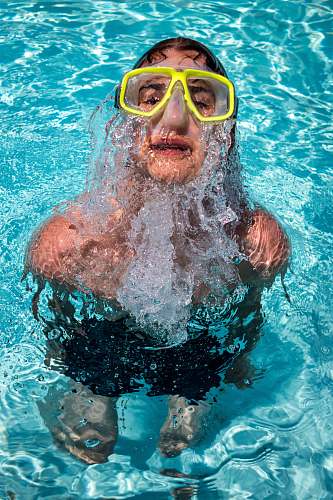 swimming woman with goggles in the pool at daytime human