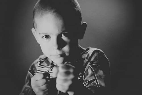 human grayscale photo of boy wearing crew-neck top grey