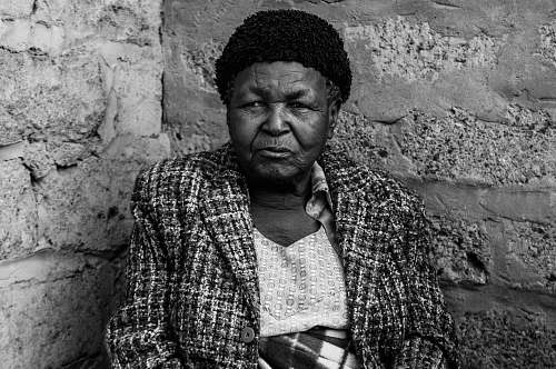 person grayscale photo of woman leaning on wall human