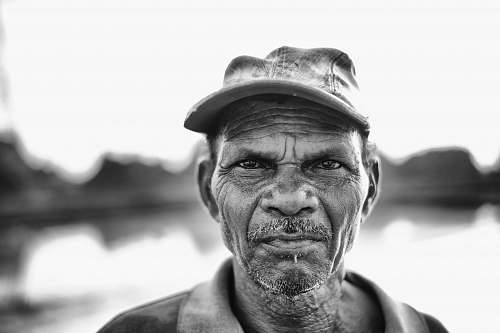 human man wearing cap near body of water during daytime portrait