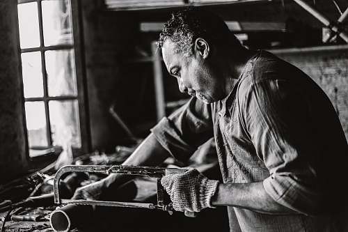 person man holding hack saw black-and-white