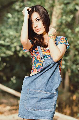 person shallow focus photography of woman wearing blue, yellow, and red floral top posing near trees people