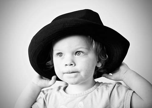 human grayscale photography of girl with hat black-and-white