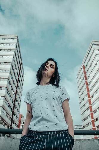 human low-angle photo of woman standing between buildinfs portrait