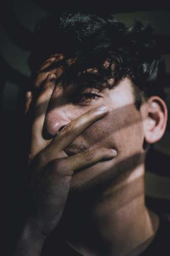 person man covering his face using his hand human