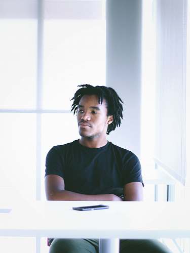 human man seating in front of white table person