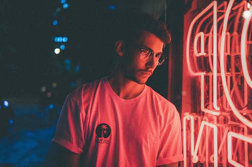 human man standing in front of pink neon light signage person