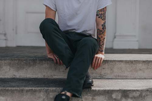 person person sitting on gray concrete flooring human
