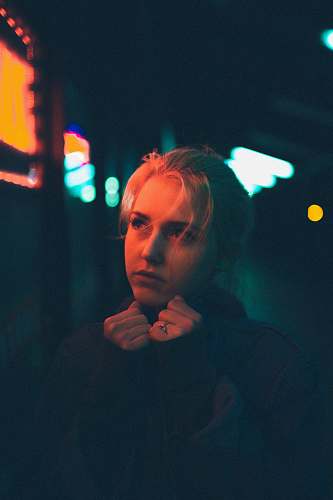 person selective focus photography of woman looking sideway while hands on chin human