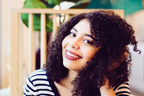human woman smiling and holding her hair person