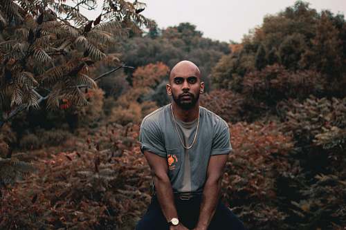 human man standing beside brown and green leafed plants people