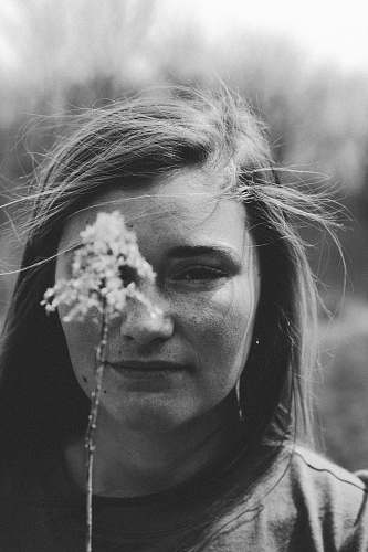 human selective focus photography of woman holding flower black-and-white