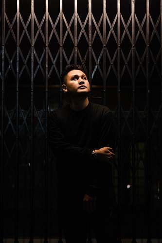 bandung minimalist photography of man standing in front metal gate indonesia