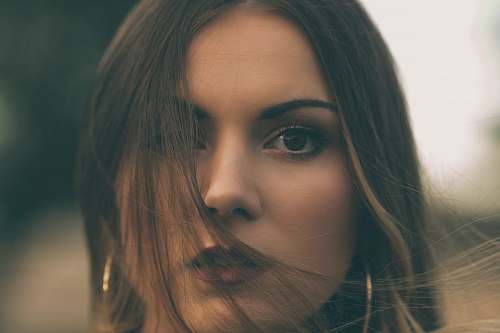 person shallow focus photo of woman in gold-colored hoop earrings face