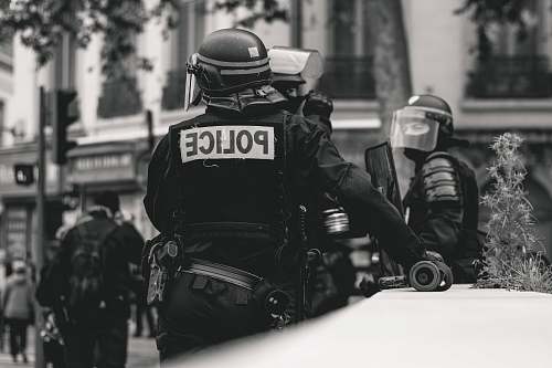 clothing grayscale photo of Police standing and leaning on wall black-and-white